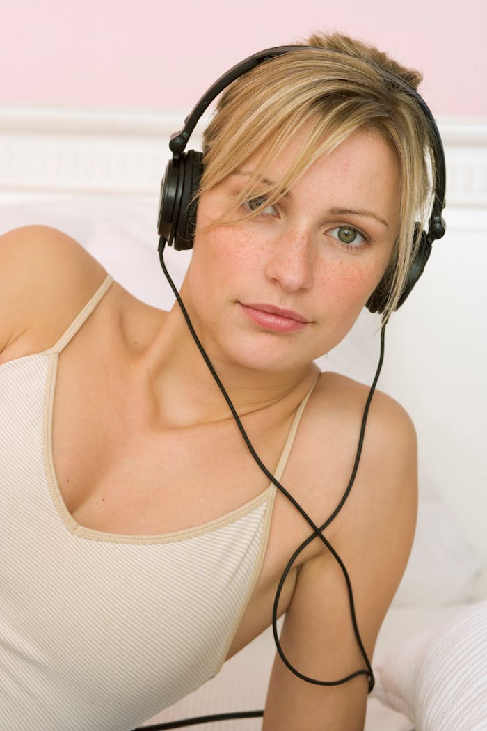 Portrait of a young woman with headphones enjoying leisure time indoors.